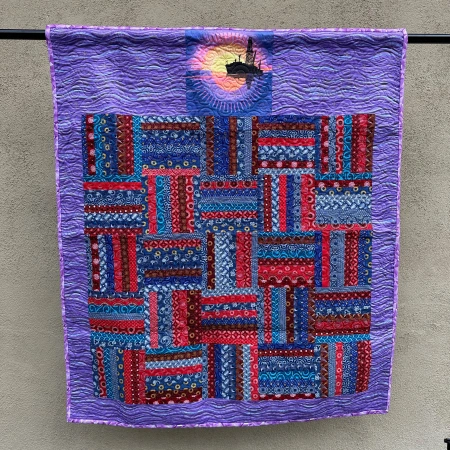 Hanging quilt with blue, red, and purple colors