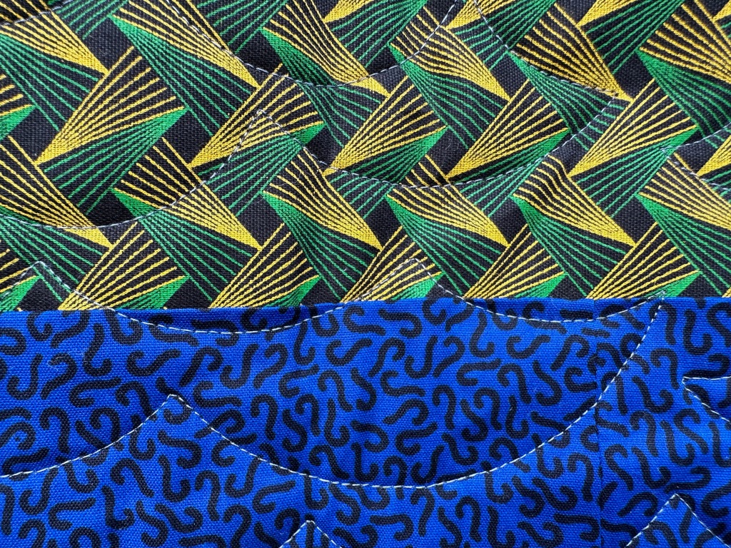Two horizontal strips of fabric - top is yellow/green, bottom is blue with black squiggles 